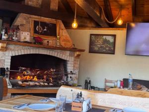 a fireplace in a dining room with a table and a table sidx sidx at Guesthouse Nefertiti in Smolyan