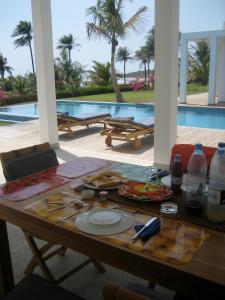 una mesa con una bandeja de comida junto a una piscina en Amigo 2 en Cap Skirring