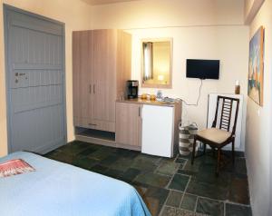 a room with a bed and a kitchen with a table at Aigaion House in Otziás