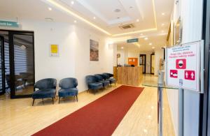 a waiting room with blue chairs and a red rug at Hotel PIO in Ulcinj +37 photos