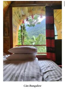 a bed in a room with a large window at A Chỉnh Homestay - Sìn Suối Hồ 