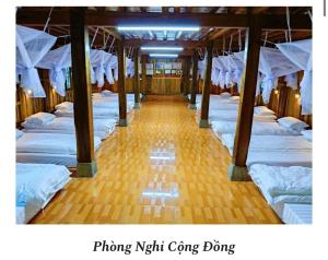a room filled with lots of white beds at A Chỉnh Homestay - Sìn Suối Hồ 