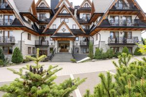 an image of the front of a lodge with trees at Sądelski Resort Apartments in Zakopane