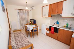 a kitchen with a table and a dining room at Limnos Family Studios in Angariónes