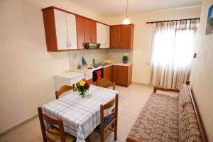 a kitchen with a table with a vase of flowers on it at Limnos Family Studios in Angariónes +16 photos