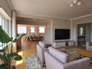 a living room with a couch and a tv at Sea View, 2 BR, Terrace & Garage in São Domingos | By Airnest in São Domingos de Rana