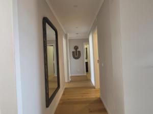a hallway with a mirror on a wall at Sea View, 2 BR, Terrace & Garage in São Domingos | By Airnest in São Domingos de Rana