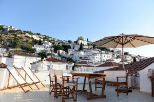 a patio with a table and chairs and an umbrella at Kalogiannis Apartments (AcquaBlue & SunnyShades) in Hydra