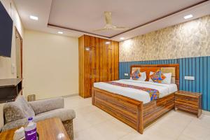 Un dormitorio con una cama, una silla y un sofá. en Via Angel Pink Residency, en Ghaziabad