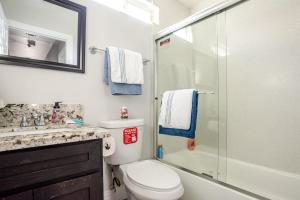 a bathroom with a toilet and a glass shower at charming home in LA prime location in Los Angeles +38 photos