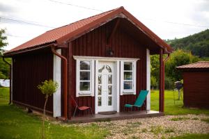 a small house with two chairs in the yard at Hodina - Holiday house Rentals in Baia Mare
