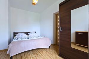 a bedroom with a bed and a wooden door at Apartament #RYMANOWSKA FV Parking Balkon in Rzeszów