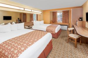 una camera d'albergo con due letti e una scrivania di Microtel by Wyndham South Bend Notre Dame University a South Bend