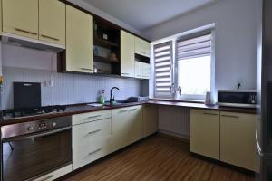 a kitchen with white cabinets and a sink and a window at Apartament #RYMANOWSKA FV Parking Balkon in Rzeszów