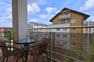 a balcony with a table and chairs and a building at Apartament #RYMANOWSKA FV Parking Balkon in Rzeszów