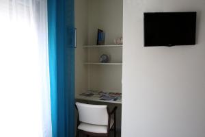 a room with a tv and a chair and a desk at Habitaciones Castelao in O Grove