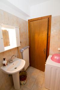 a bathroom with a sink and a wooden door at Limnos Family Studios in Angariónes