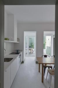 kuchnia z białymi szafkami i drewnianym stołem w obiekcie Embaixador 26: Belem Serviced Apartments w Lizbonie