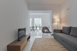 uma sala de estar com um sofá e uma televisão em Embaixador 26: Belem Serviced Apartments em Lisboa