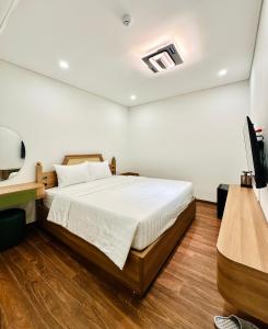 a bedroom with a bed and a television in it at Momento Phu Quoc Hotel in Phu Quoc