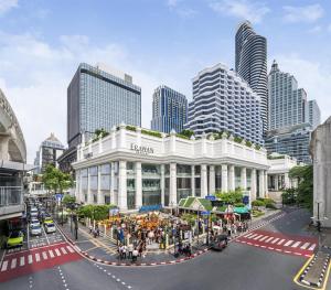 eine Stadtstraße mit einem weißen Gebäude vor einer Stadt in der Unterkunft Grand Hyatt Erawan Bangkok in Bangkok + 37 Fotos