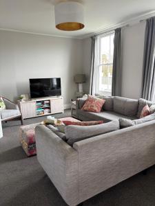 a living room with a couch and a flat screen tv at Luxury Village Villa 200metres from Village in Havelock North