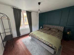 a bedroom with a large bed with a green headboard at Appartement Sedan in Sedan