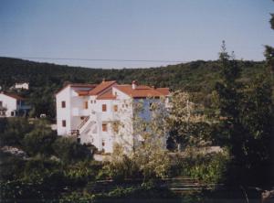 a white house in the middle of a mountain at Apartment Marija in Brbinj