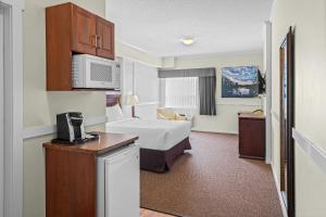 a hotel room with a bed and a microwave at Days Inn by Wyndham Lamont in Lamont