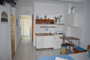 a kitchen with white cabinets and a sink at House Mantesos in Koinyra