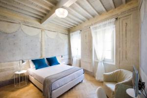 a bedroom with a bed with blue pillows and a couch at Il Piccolo Cavour Charming House B&B in Arezzo