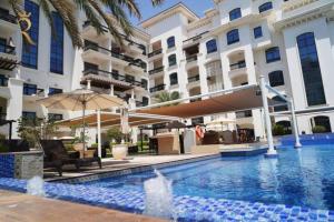 a swimming pool in front of a building at Supernova Haven 1BR - Near Yas Mall & Marina in Abu Dhabi