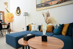 a living room with a blue couch and a table at Modern 1BR - Yas Island Natural Chic Escape in Abu Dhabi