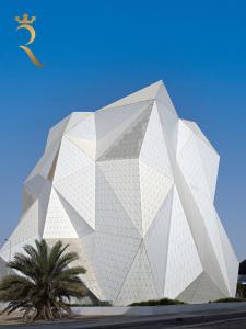 a large white building with a palm tree in front of it at Modern 1BR - Yas Island Natural Chic Escape in Abu Dhabi