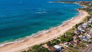 an aerial view of a beach with houses and the ocean at Cute Beach Cottage - Absolute Beach Front in Toukley