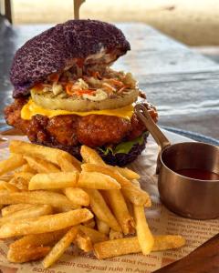 a hamburger and french fries on a table at Reef Beach Resort in General Luna +8 photos