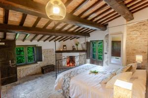 a bedroom with a large bed and a fireplace at Respiro Umbria, 1500s Villa with Unique Biopool in Spoleto