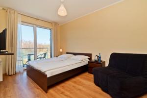a bedroom with a bed and a couch at HORN Jastarnia in Jastarnia +40 photos