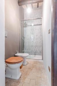 a bathroom with a toilet and a shower at Respiro Umbria, 1500s Villa with Unique Biopool in Spoleto +35 photos