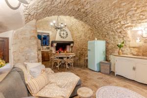 a living room with a couch and a stone wall at Respiro Umbria, 1500s Villa with Unique Biopool in Spoleto