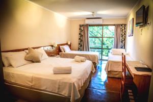 a hotel room with two beds and a window at Rainforest Hotel & Cabañas in Puerto Iguazú +132 photos
