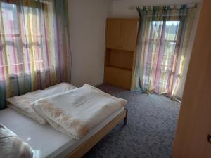 a small bedroom with a bed with a blanket on it at Ferienwohnung Schmid in Waldkirchen