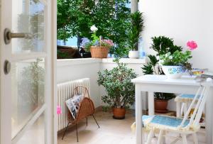 a balcony with plants and a table and a window at Apartments Nest in Novi Sad