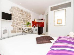 Un dormitorio con una cama grande y una pared de piedra. en Apartment Lee Loo - Studio Apartment, en Dubrovnik