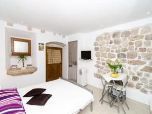 Un dormitorio con una cama y una pared de piedra. en Apartment Lee Loo - Studio Apartment, en Dubrovnik 4 fotos más