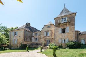 une vieille maison en pierre avec une tour sur un champ dans l'établissement Château des Salettes, à Anoye