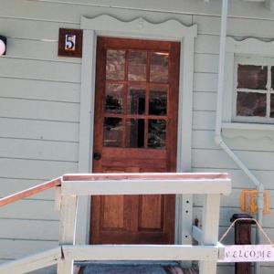 a house with a wooden door with a sign on it at Huntington Lake Resort and Marina in Lakeshore
