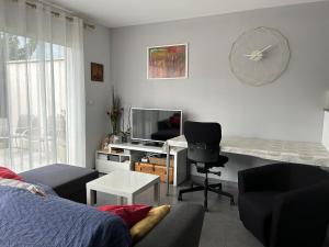 a living room with a couch and a desk with a television at Maison individuelle à 10 mn à pied du centre ville in Uzès