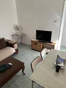 a living room with a couch and a tv at *** DiDiM BEYAZ *** in Didim