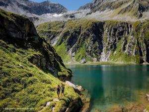 two people standing on a path near a mountain lake at Chalet in Königsleiten by Zillertal Ski Arena in Wald im Pinzgau +27 photos